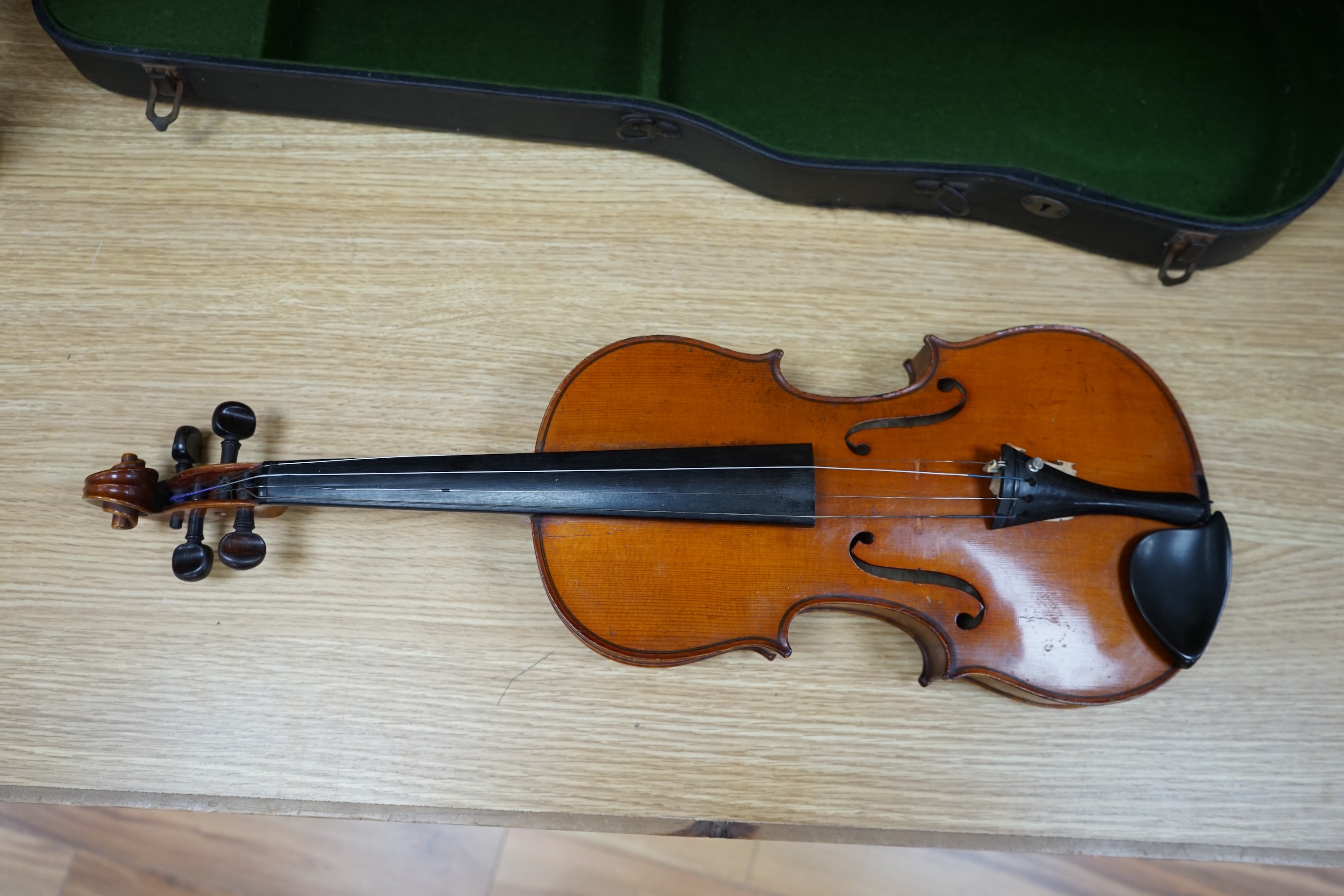 A cased early 20th century violin with bow, no label, back measures 35.5cm. Condition - fair to good